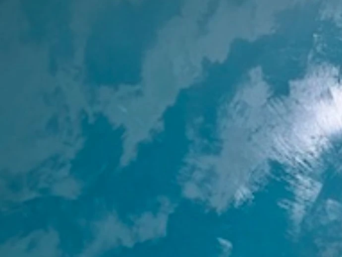 Met de kwast geschilderde wolkenlucht in blauw en wit op een volledige wand